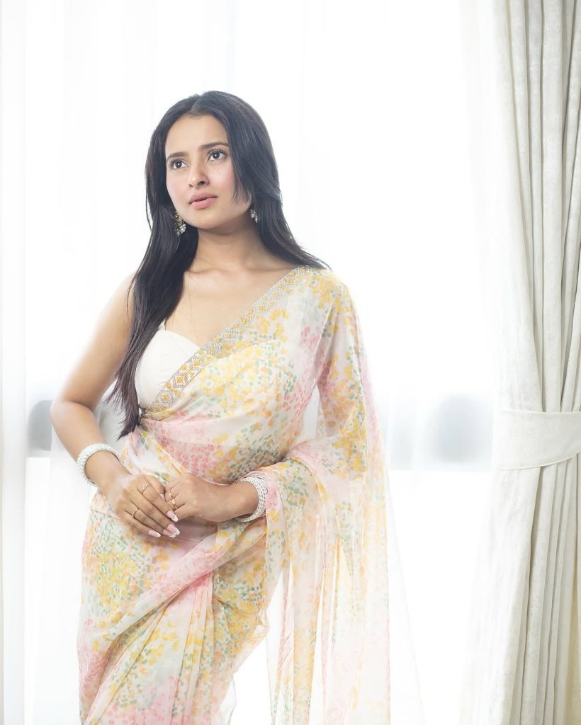 Aarushi Baruah posing gracefully in flowing white transparent saree