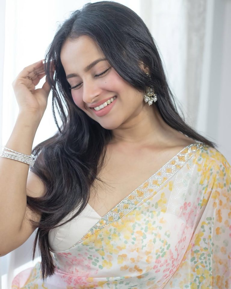 Aarushi Baruah posing gracefully in flowing white transparent saree