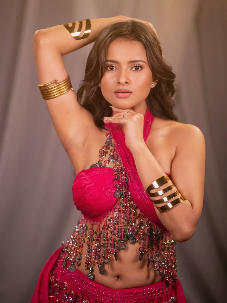 Aarushi Baruah posing confidently in fitted pink dress outfit