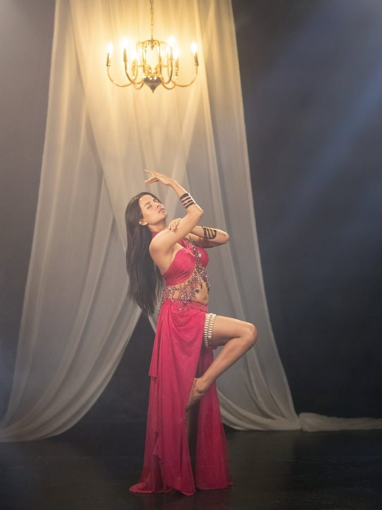 Aarushi Baruah posing confidently in fitted pink dress outfit