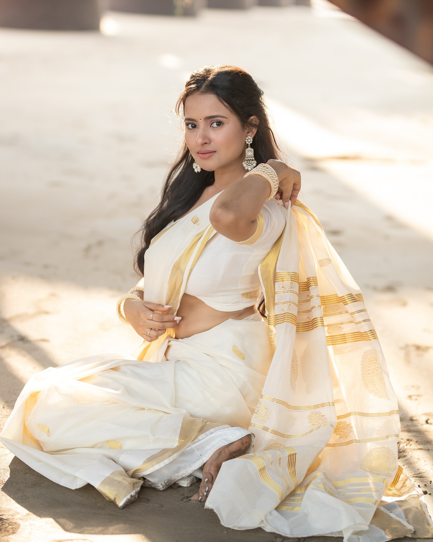 Aarushi Baruah posing gracefully in flowing white saree ensemble