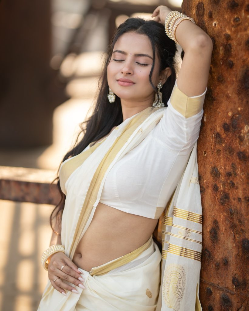 Aarushi Baruah posing gracefully in flowing white saree ensemble