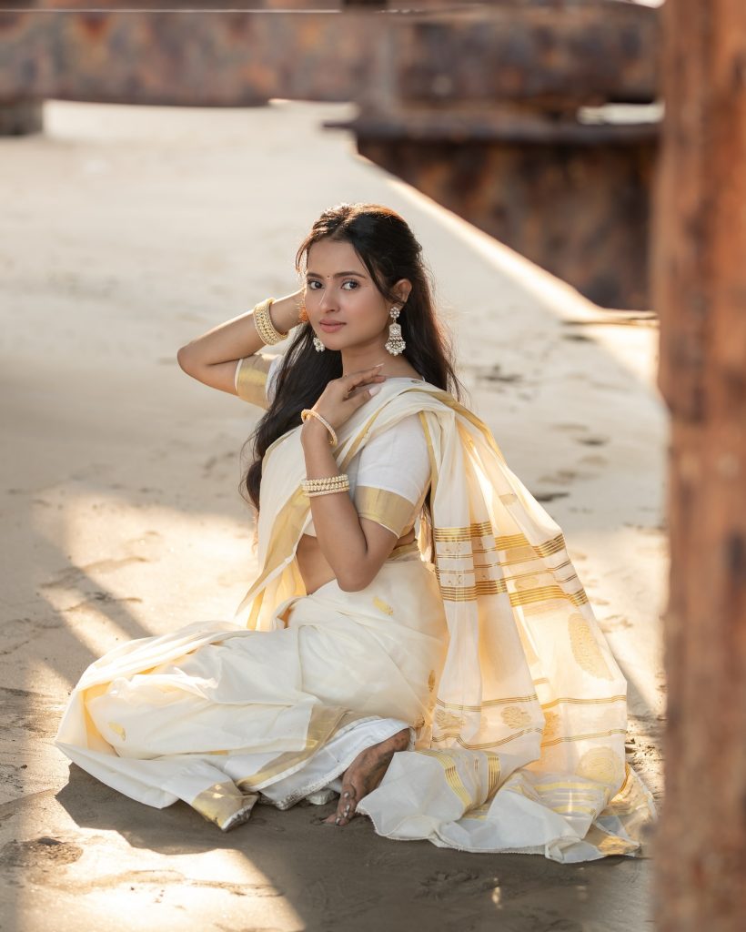 Aarushi Baruah posing gracefully in flowing white saree ensemble