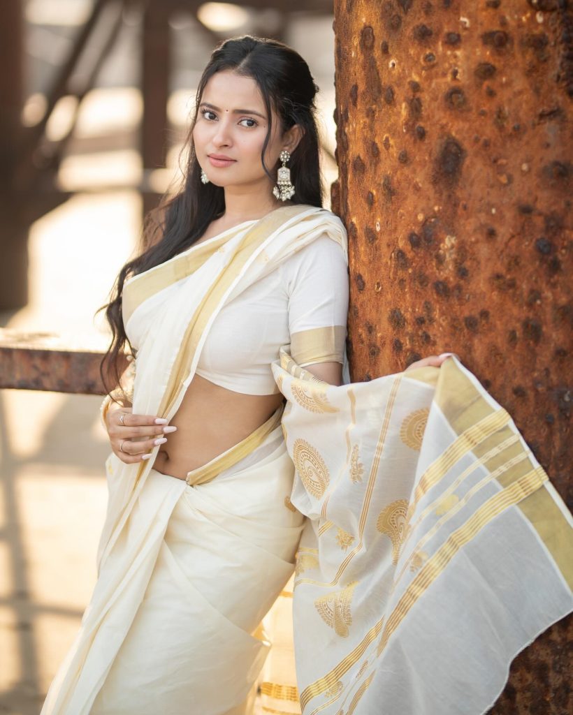 Aarushi Baruah posing gracefully in flowing white saree ensemble