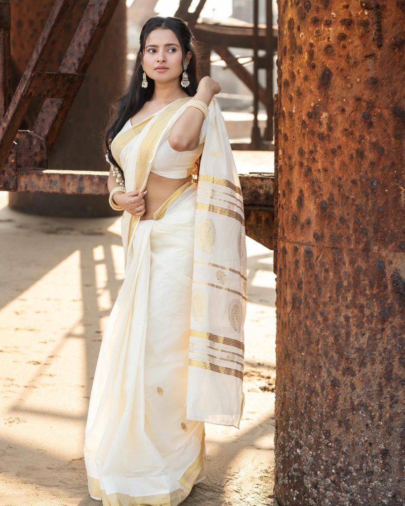 Aarushi Baruah posing gracefully in flowing white saree ensemble