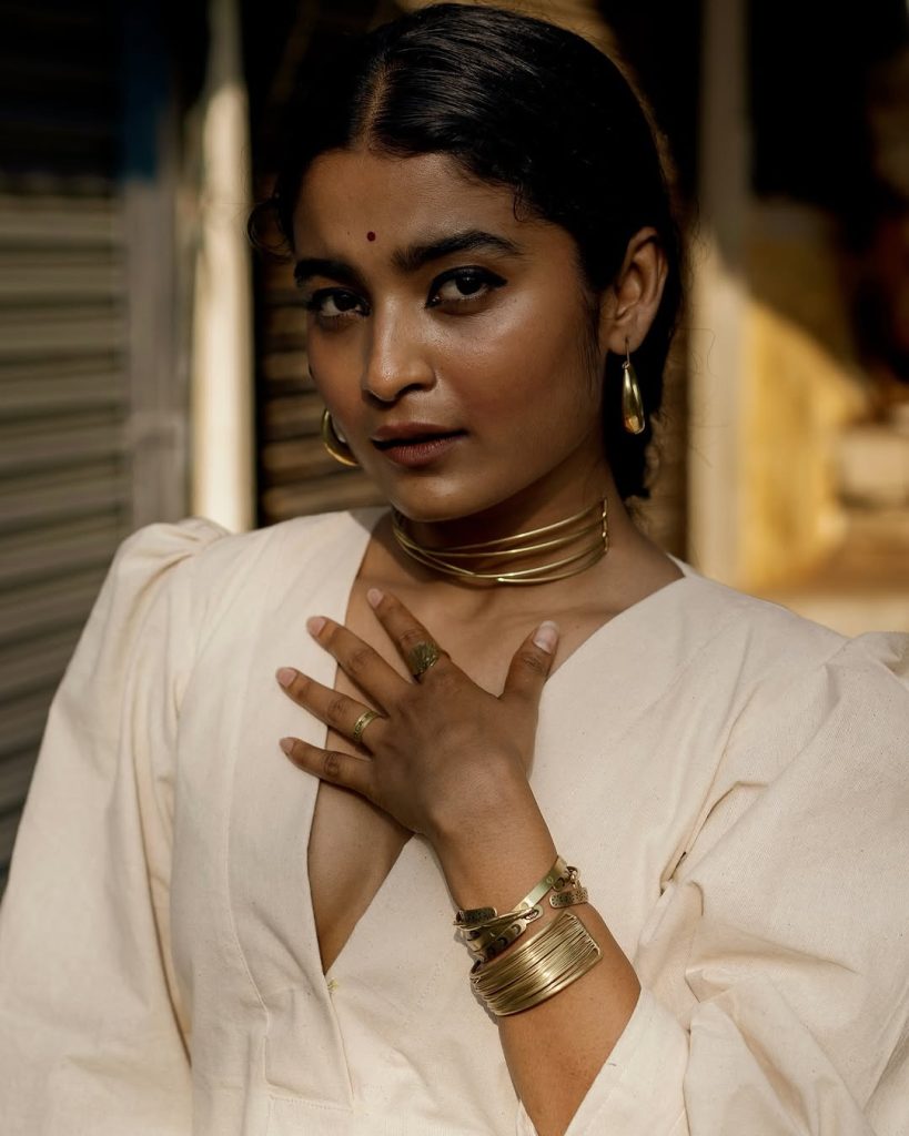 Chaithra J Achar posing gracefully in flowing white dress ensemble