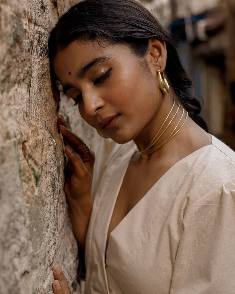 Chaithra J Achar posing gracefully in flowing white dress ensemble