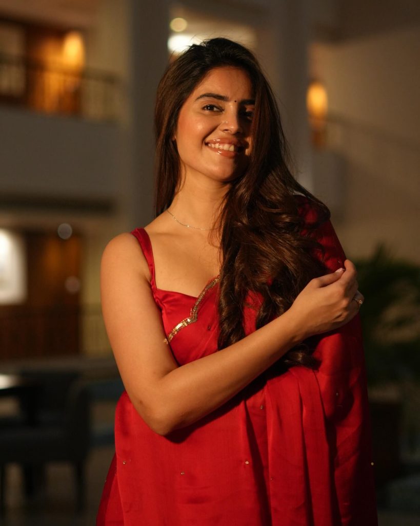 Kushitha Kallapu posing confidently in vibrant red saree