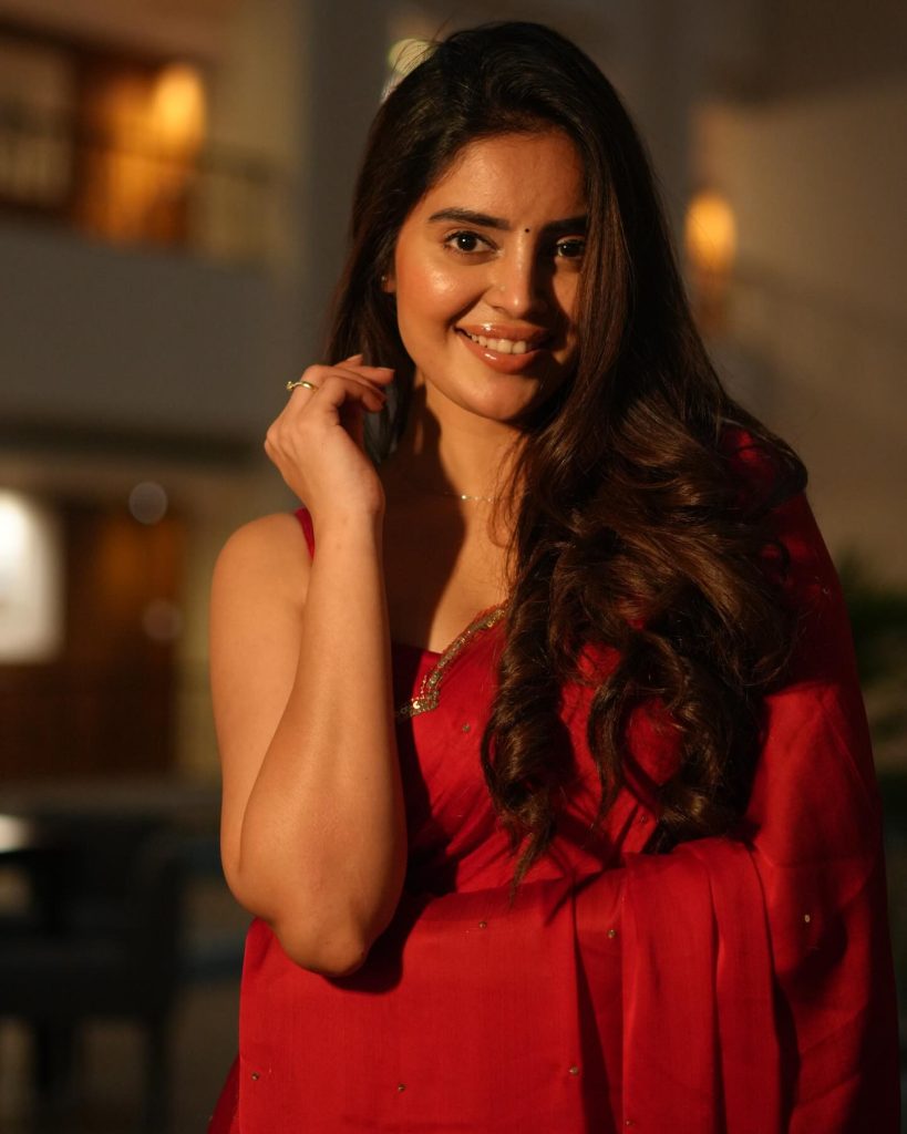 Kushitha Kallapu posing confidently in vibrant red saree