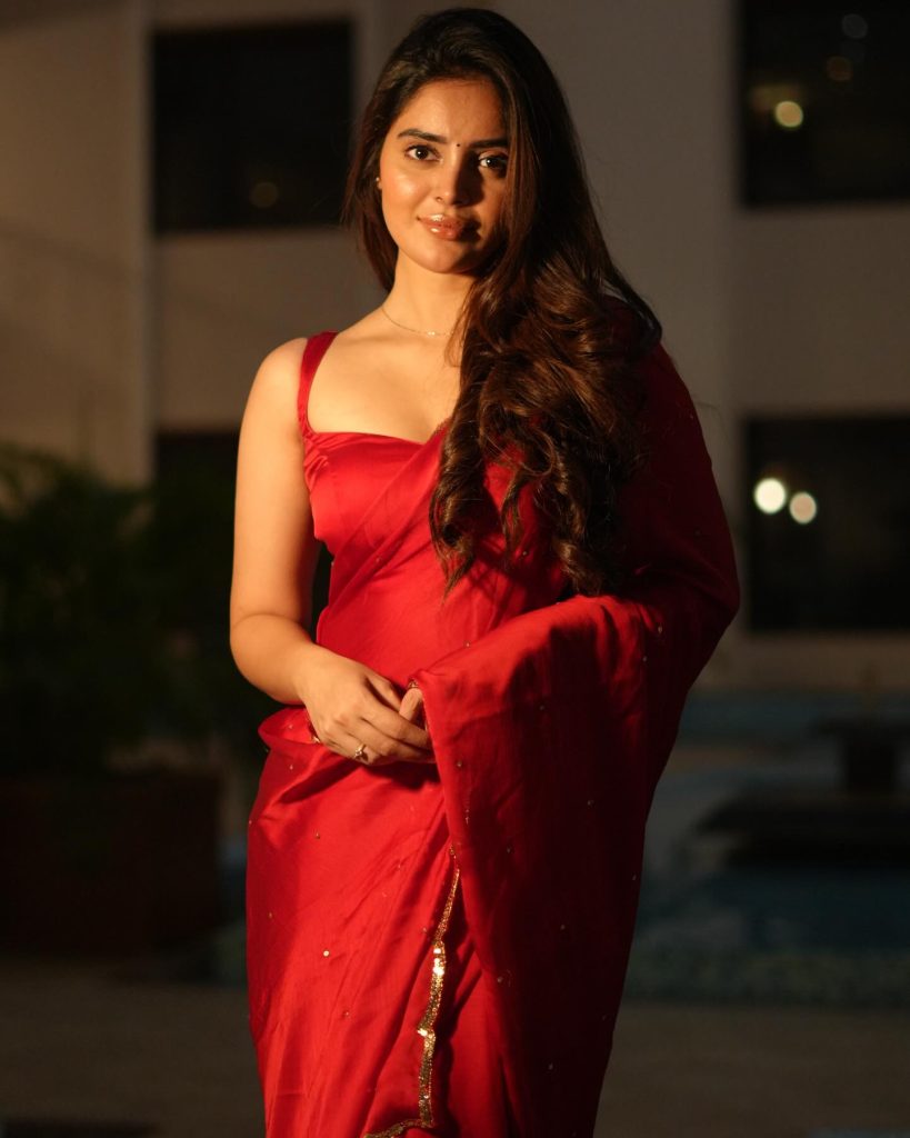 Kushitha Kallapu posing confidently in vibrant red saree