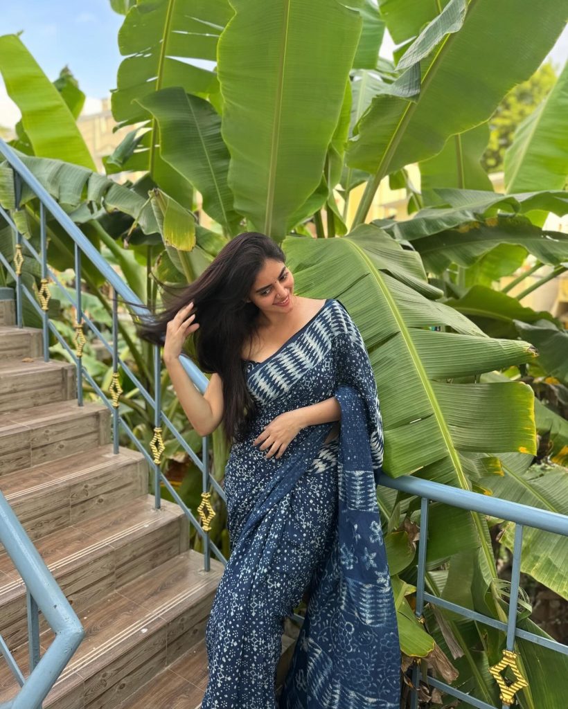 Kushitha Kallapu posing in blue saree among greenery and trees