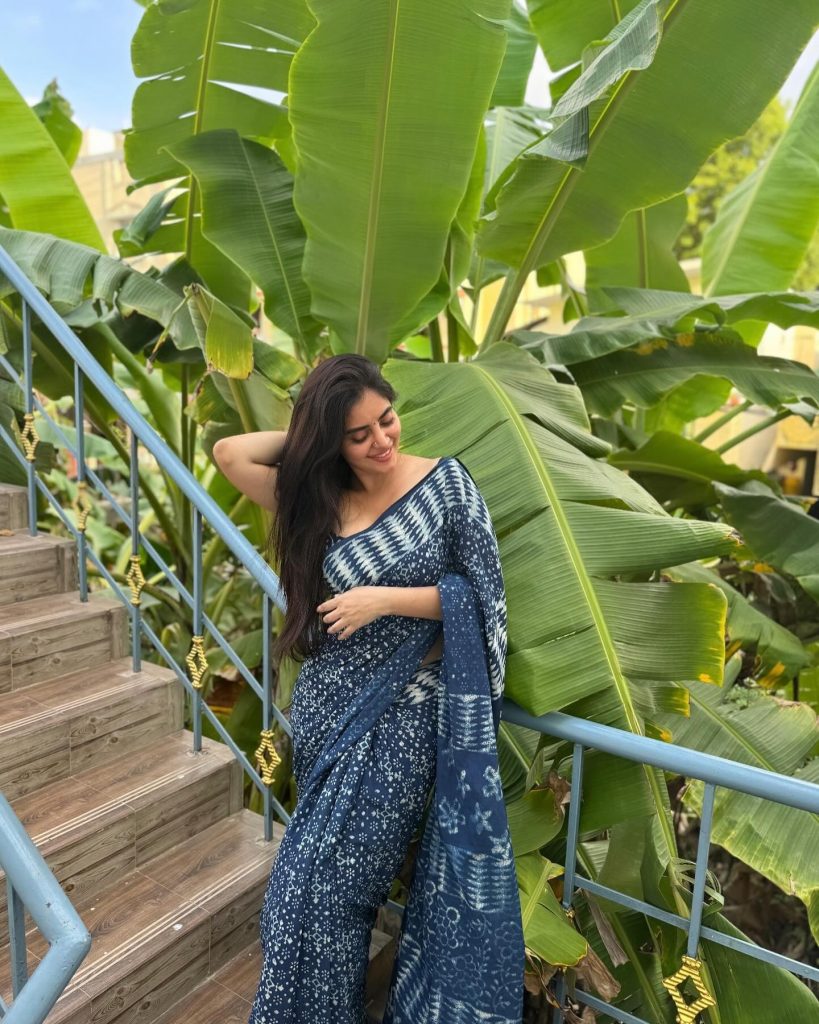Kushitha Kallapu posing in blue saree among greenery and trees