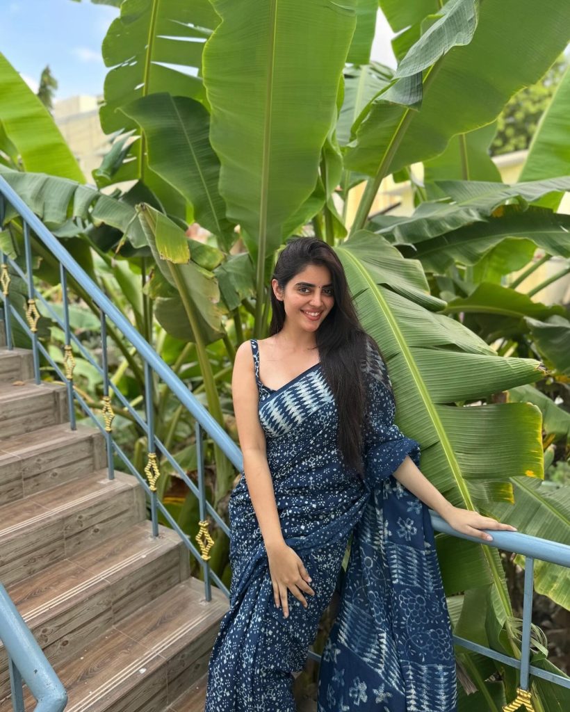 Kushitha Kallapu posing in blue saree among greenery and trees