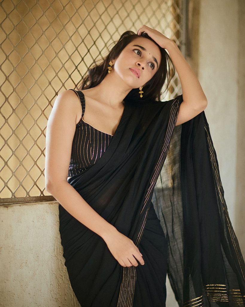Nuveksha wearing stunning black saree in glamorous photoshoot