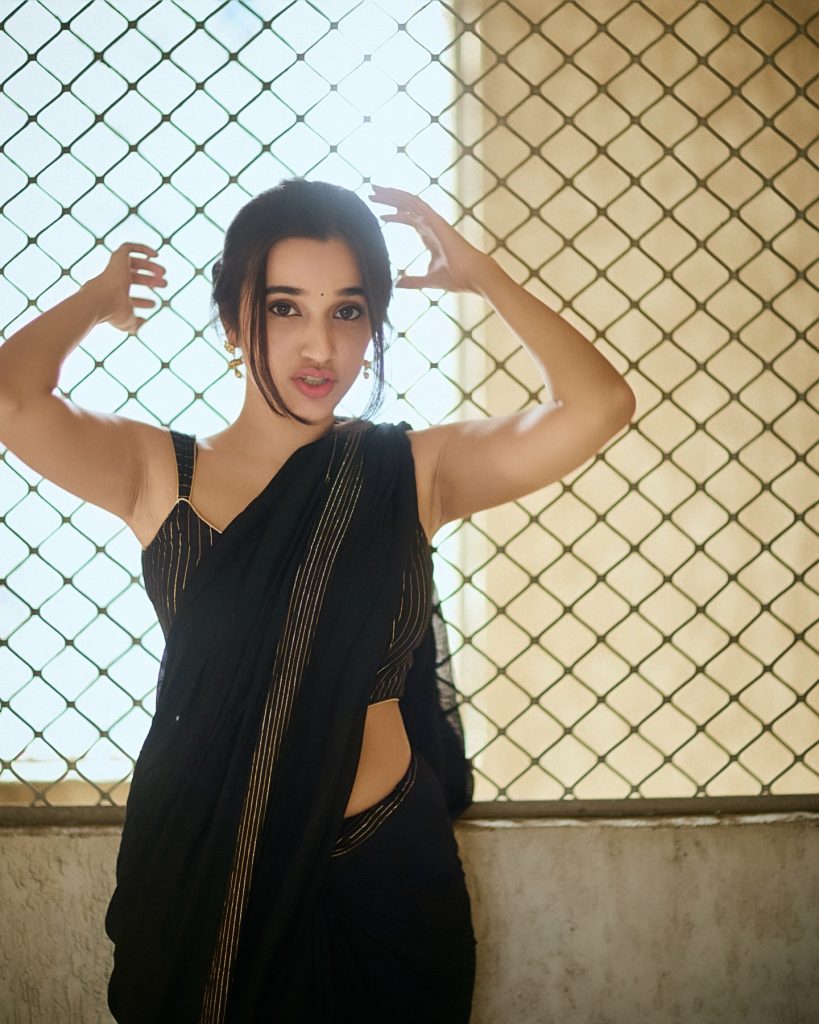 Nuveksha wearing stunning black saree in glamorous photoshoot