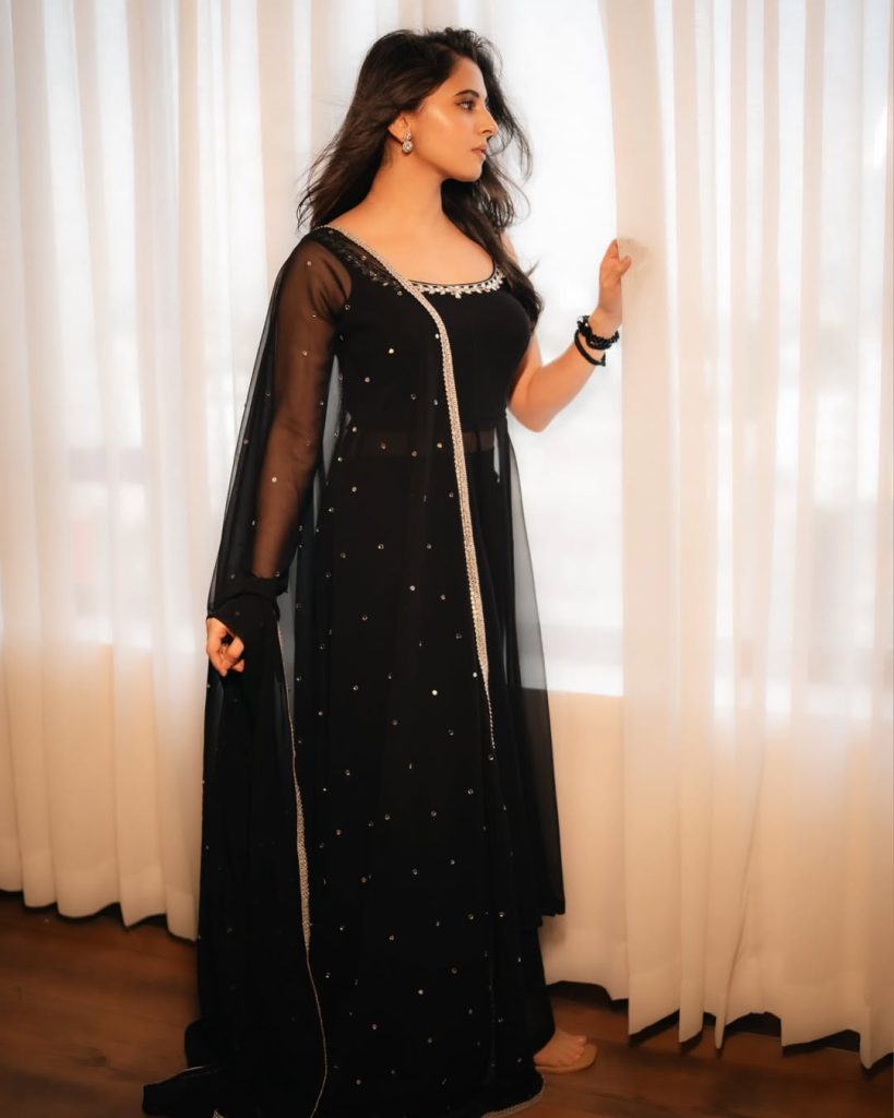 Preethi Asrani posing elegantly in fitted black dress ensemble
