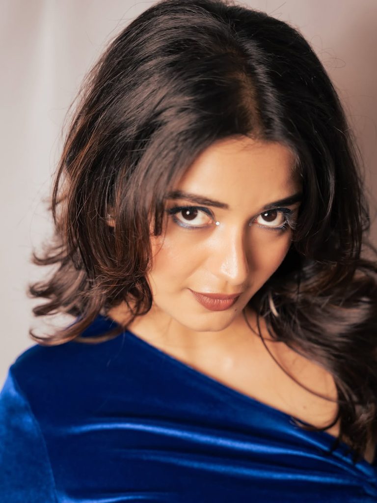 Priyanka Jain posing casually in fitted blue shirt