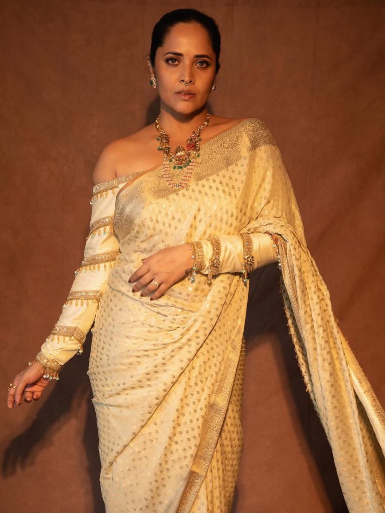 Classic white saree styling demonstrates Anasuya's timeless fashion principles