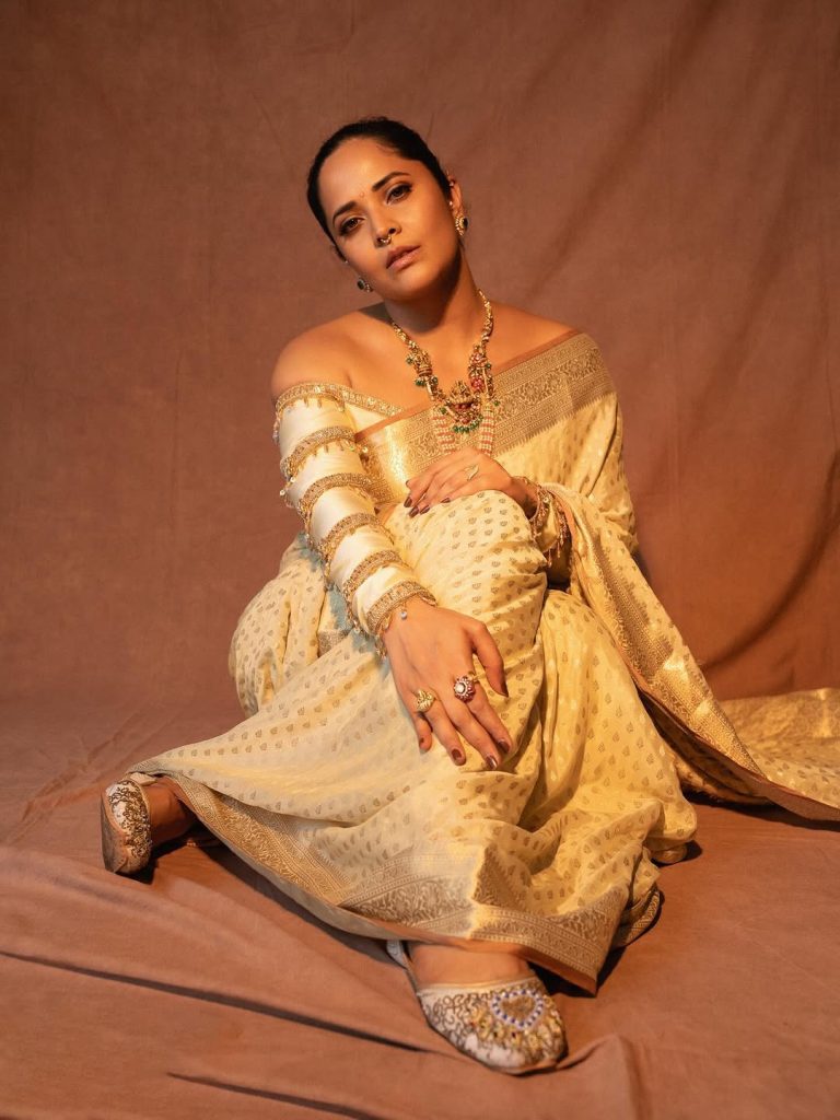 Elegant white draping showcases Anasuya's traditional fashion expertise