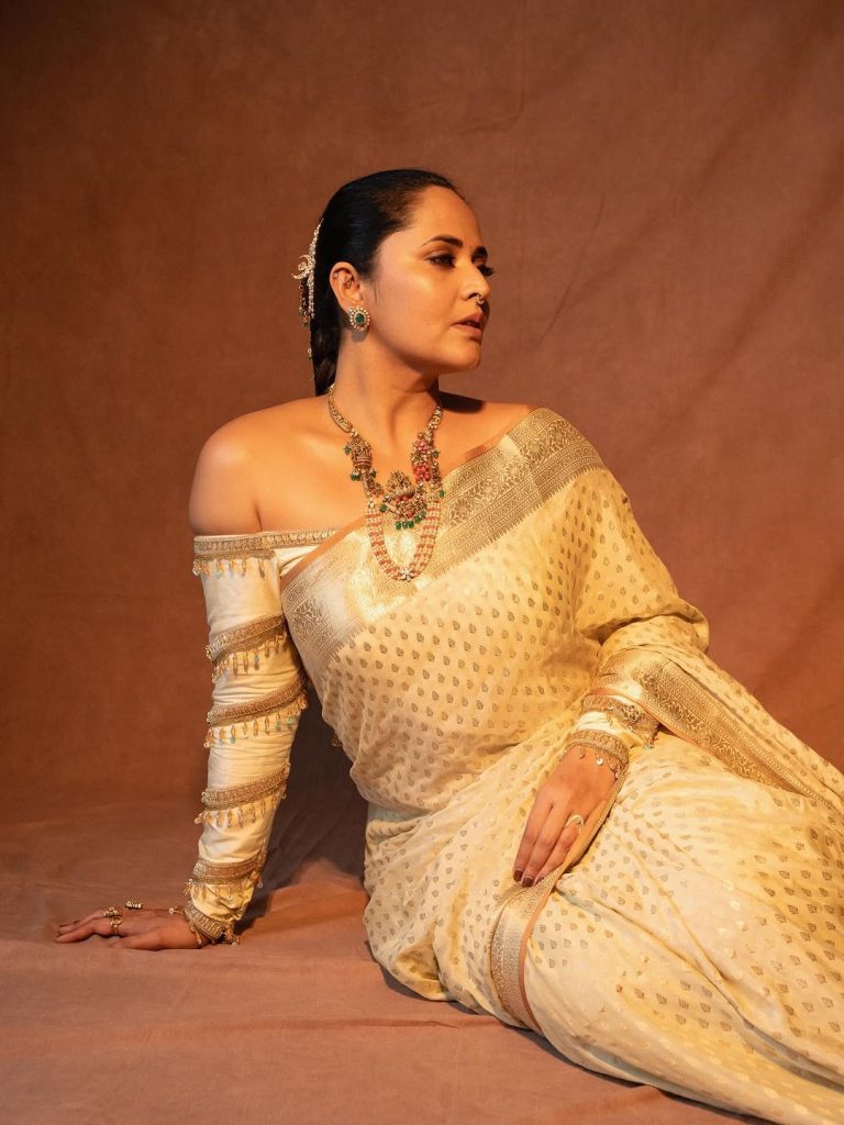 Elegant white draping showcases Anasuya's traditional fashion expertise