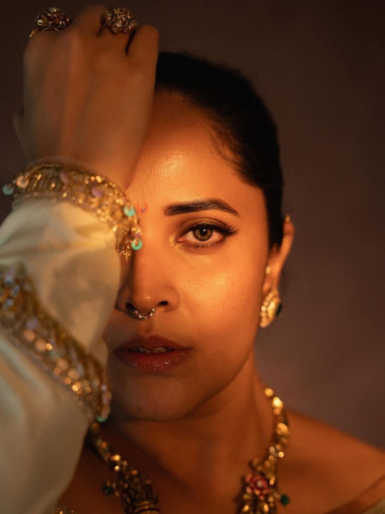 Elegant white draping showcases Anasuya's traditional fashion expertise