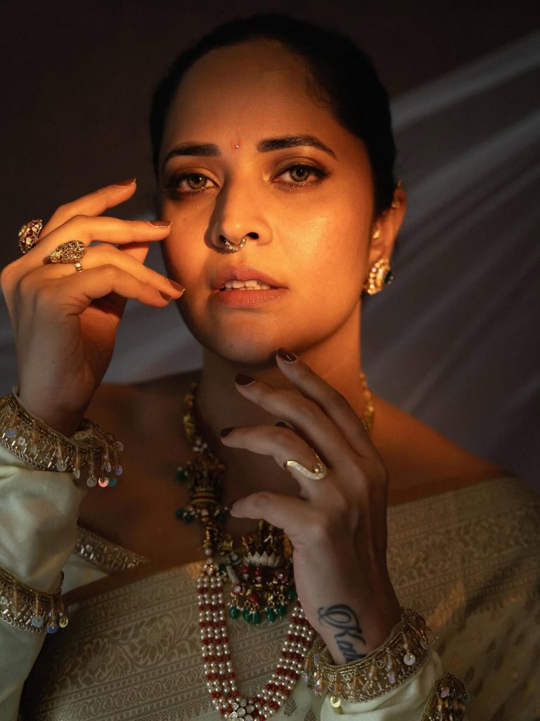 Classic white saree styling demonstrates Anasuya's timeless fashion principles