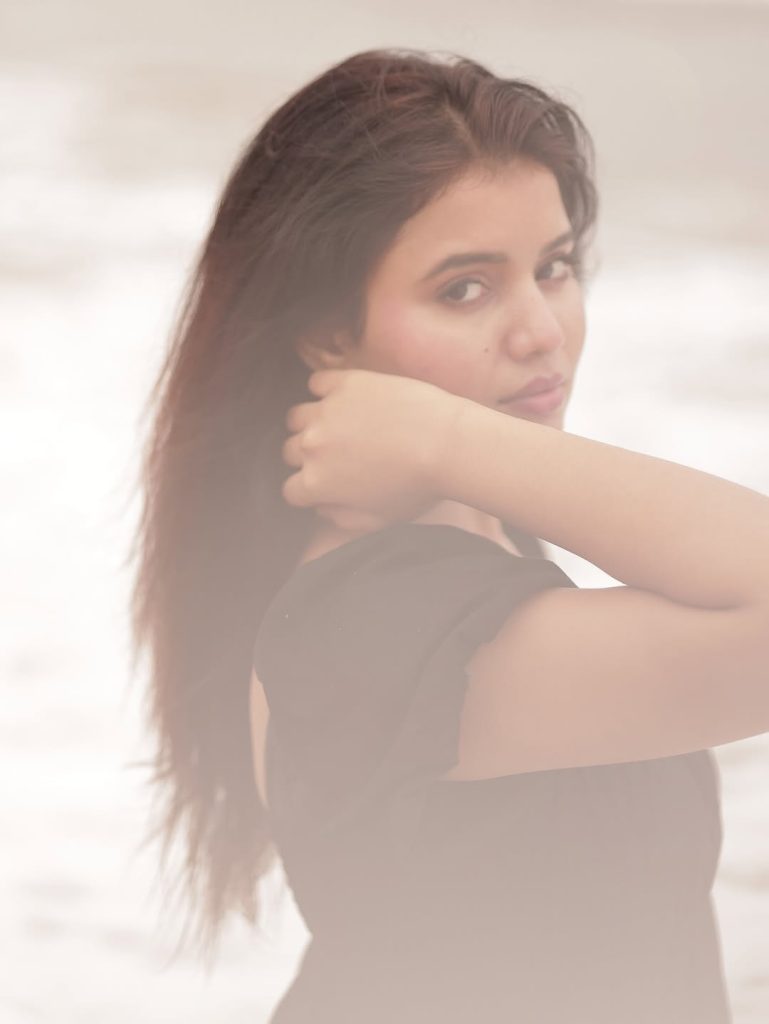 Ocean waves provide natural backdrop for Arul Jyothi's black dress beach styling