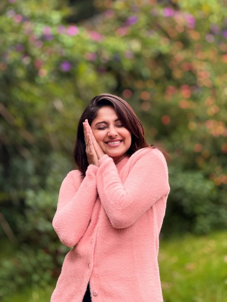 Blooming flowers frame Aysha's radiant beauty in garden setting