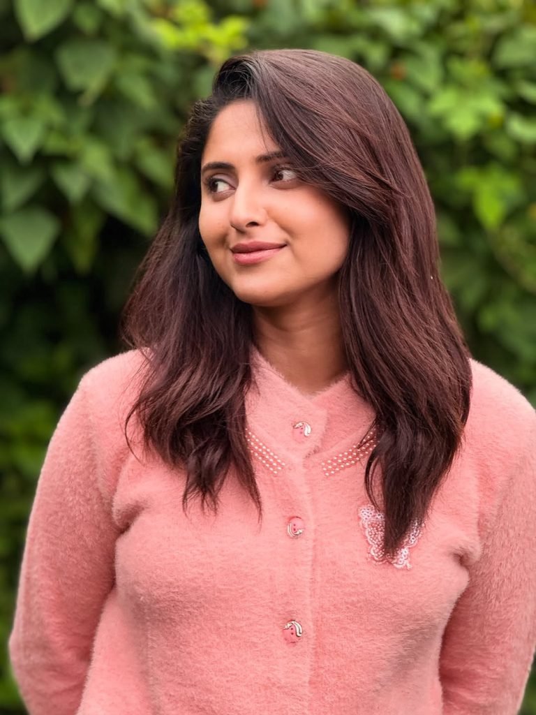 Blooming flowers frame Aysha's radiant beauty in garden setting