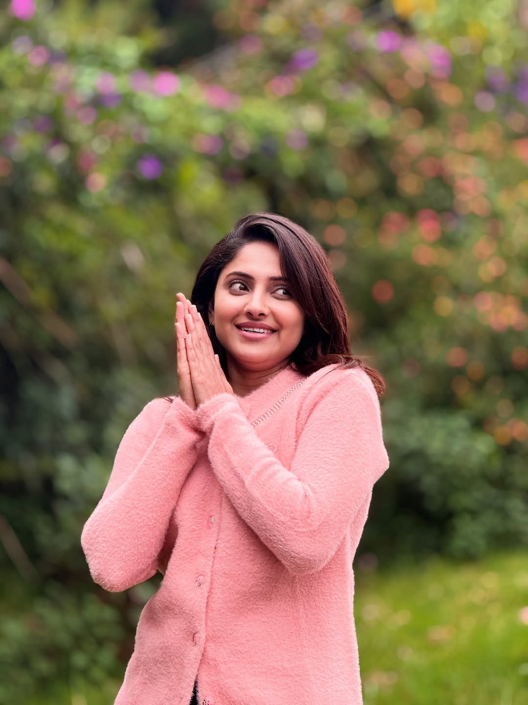 Blooming flowers frame Aysha's radiant beauty in garden setting