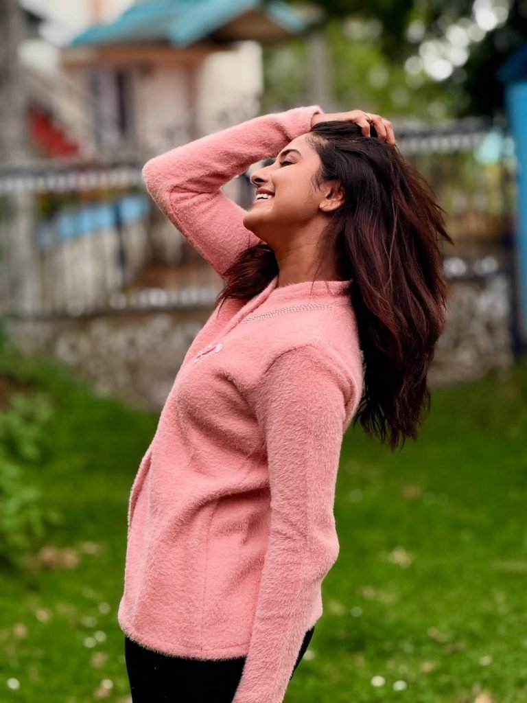 Blooming flowers frame Aysha's radiant beauty in garden setting