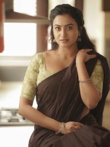 Olive green printed blouse adds perfect accent to Janani Ashok Kumar's brown saree