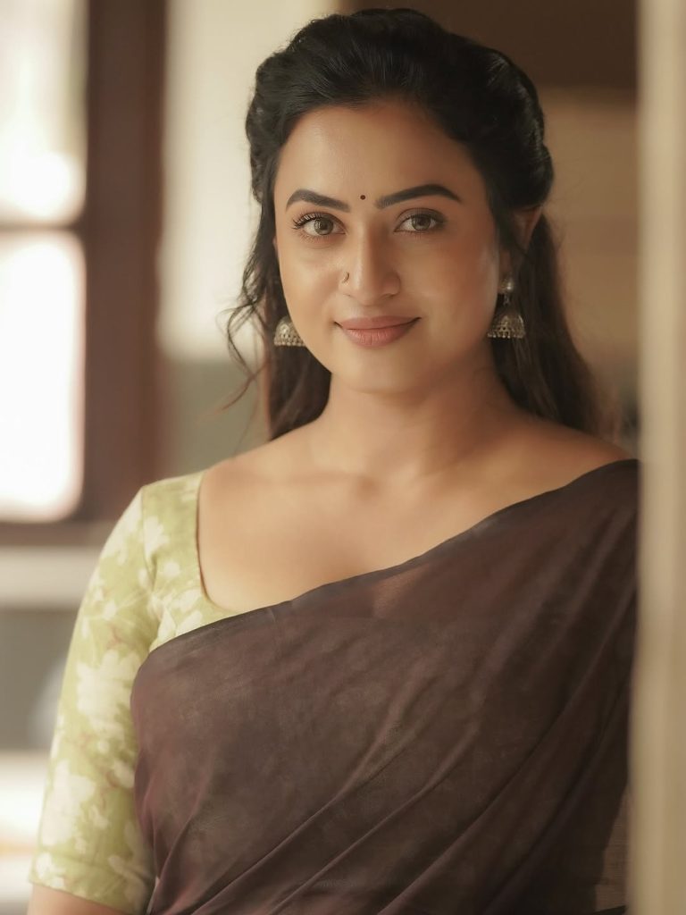 Olive green printed blouse adds perfect accent to Janani Ashok Kumar's brown saree