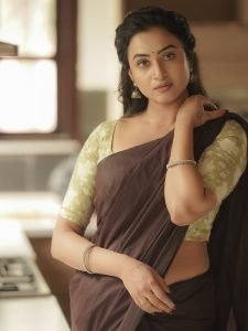 Olive green printed blouse adds perfect accent to Janani Ashok Kumar's brown saree
