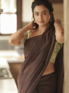 Olive green printed blouse adds perfect accent to Janani Ashok Kumar's brown saree