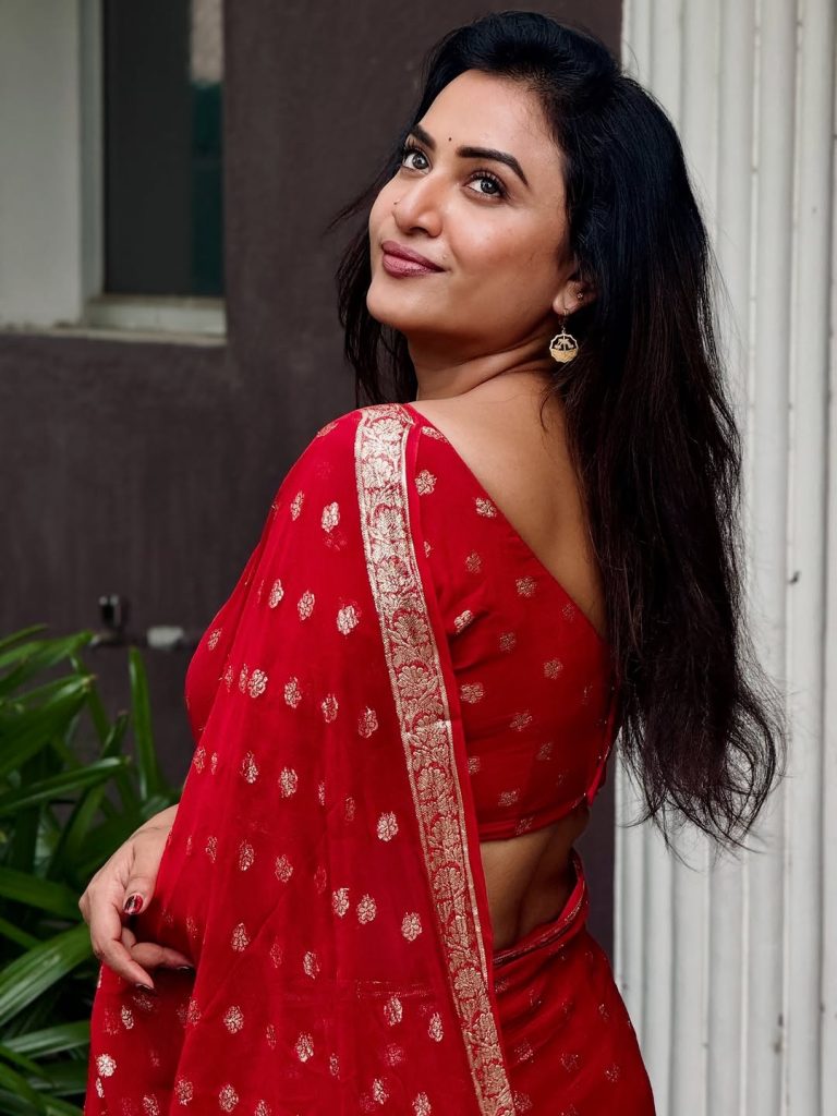 Luxurious gold zari detailing enhances Janani Ashok Kumar's red saree presentation