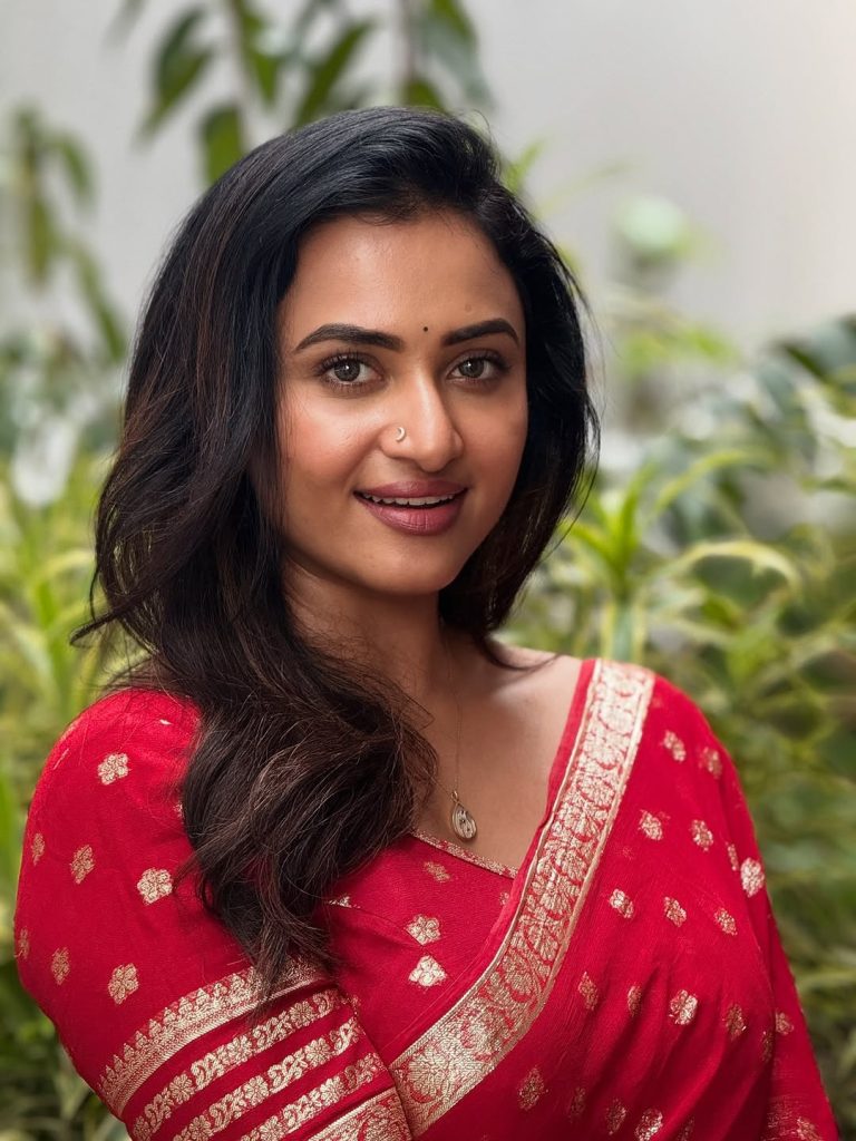 Luxurious gold zari detailing enhances Janani Ashok Kumar's red saree presentation