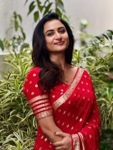 Luxurious gold zari detailing enhances Janani Ashok Kumar's red saree presentation