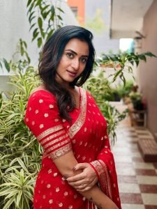 Luxurious gold zari detailing enhances Janani Ashok Kumar's red saree presentation