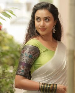 Elegant white saree coordination showcases Janani Ashok Kumar's embroidered green blouse