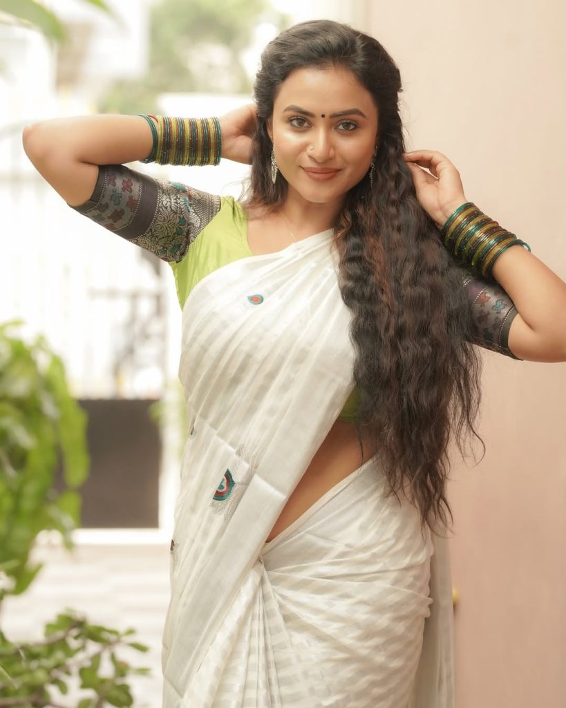 Elegant white saree coordination showcases Janani Ashok Kumar's embroidered green blouse
