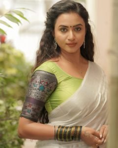Elegant white saree coordination showcases Janani Ashok Kumar's embroidered green blouse