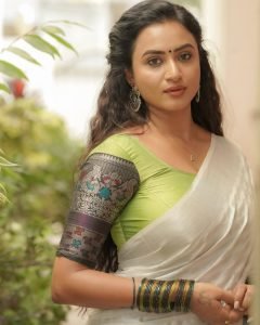 Elegant white saree coordination showcases Janani Ashok Kumar's embroidered green blouse