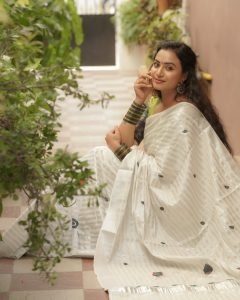 Elegant white saree coordination showcases Janani Ashok Kumar's embroidered green blouse