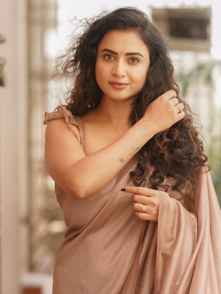 Janani Ashok Kumar embodies grace in brown drape with flowing loose curls