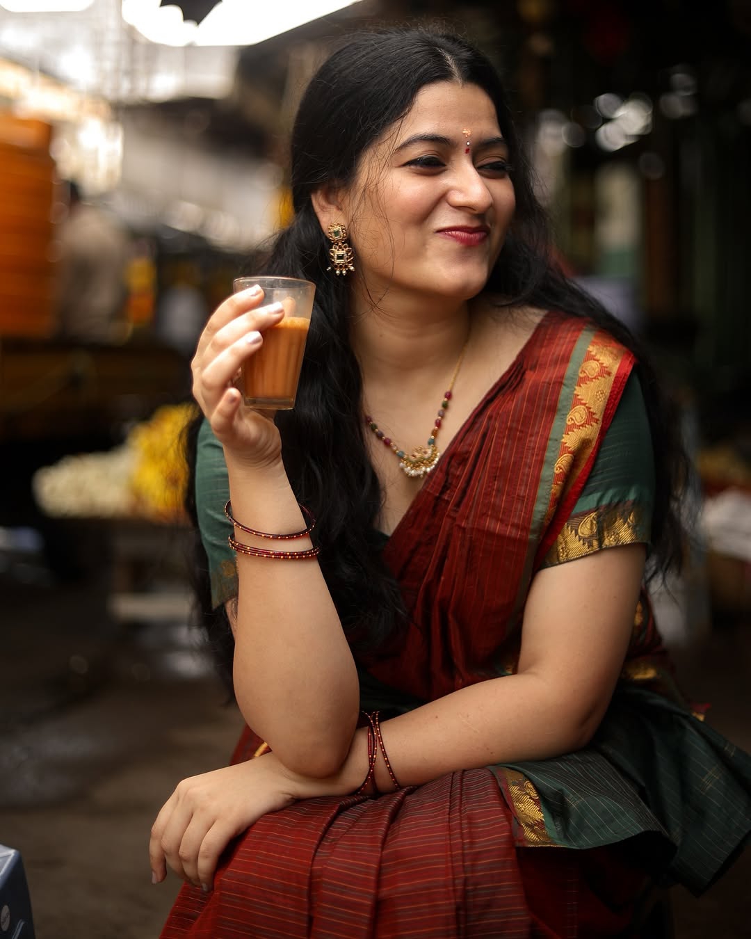 Cute expressions enhanced by Kanduri Sudha's rich maroon saree's earthy elegance