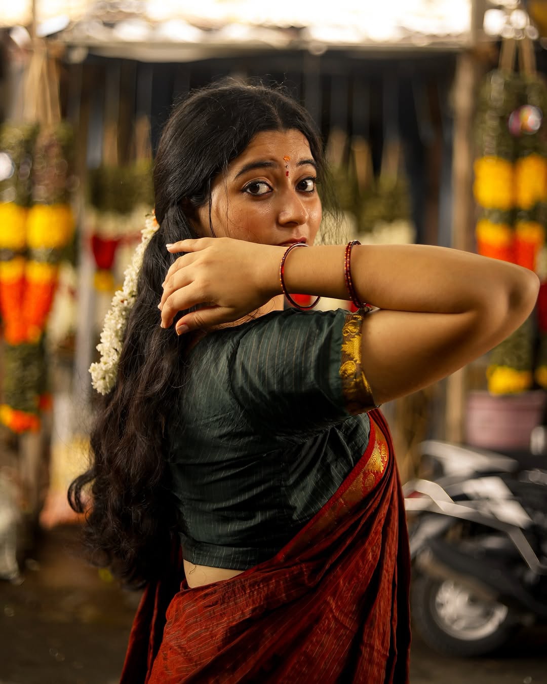 Cute expressions enhanced by Kanduri Sudha's rich maroon saree's earthy elegance