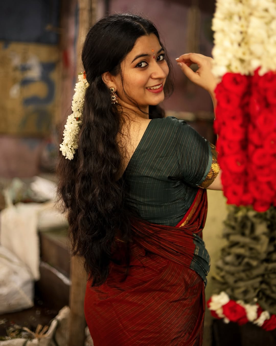 Cute expressions enhanced by Kanduri Sudha's rich maroon saree's earthy elegance