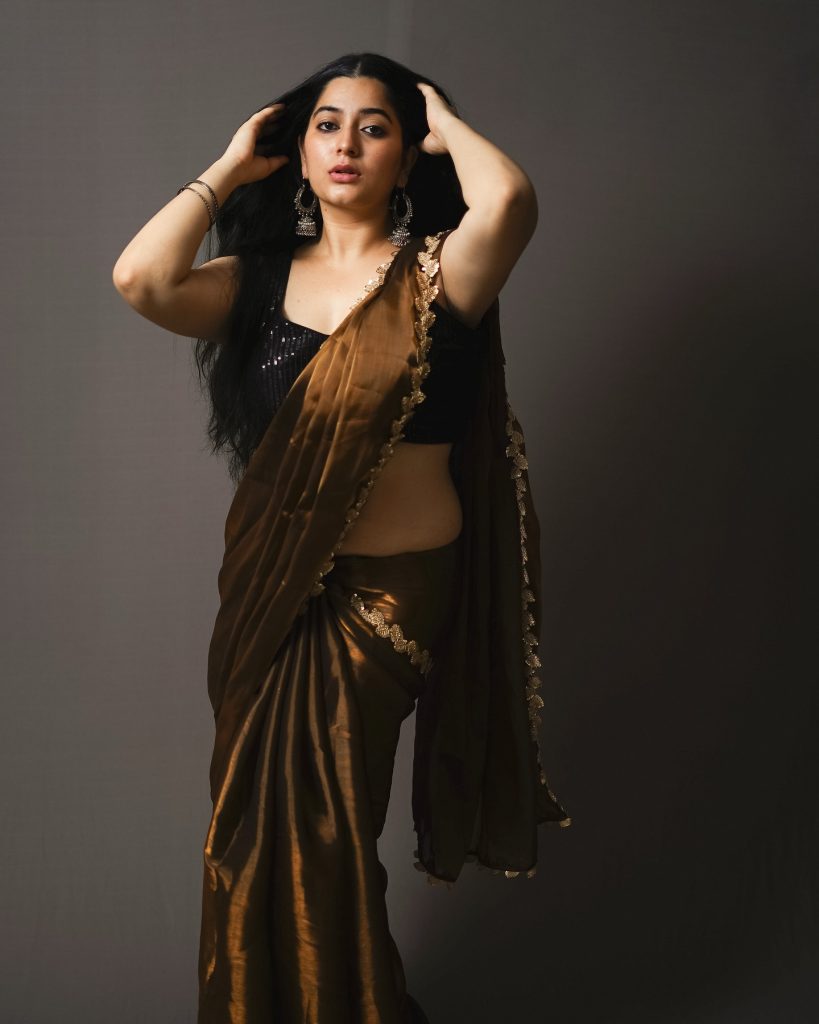 Rich chocolate brown saree drapes elegantly on Kanduri Sudha's figure