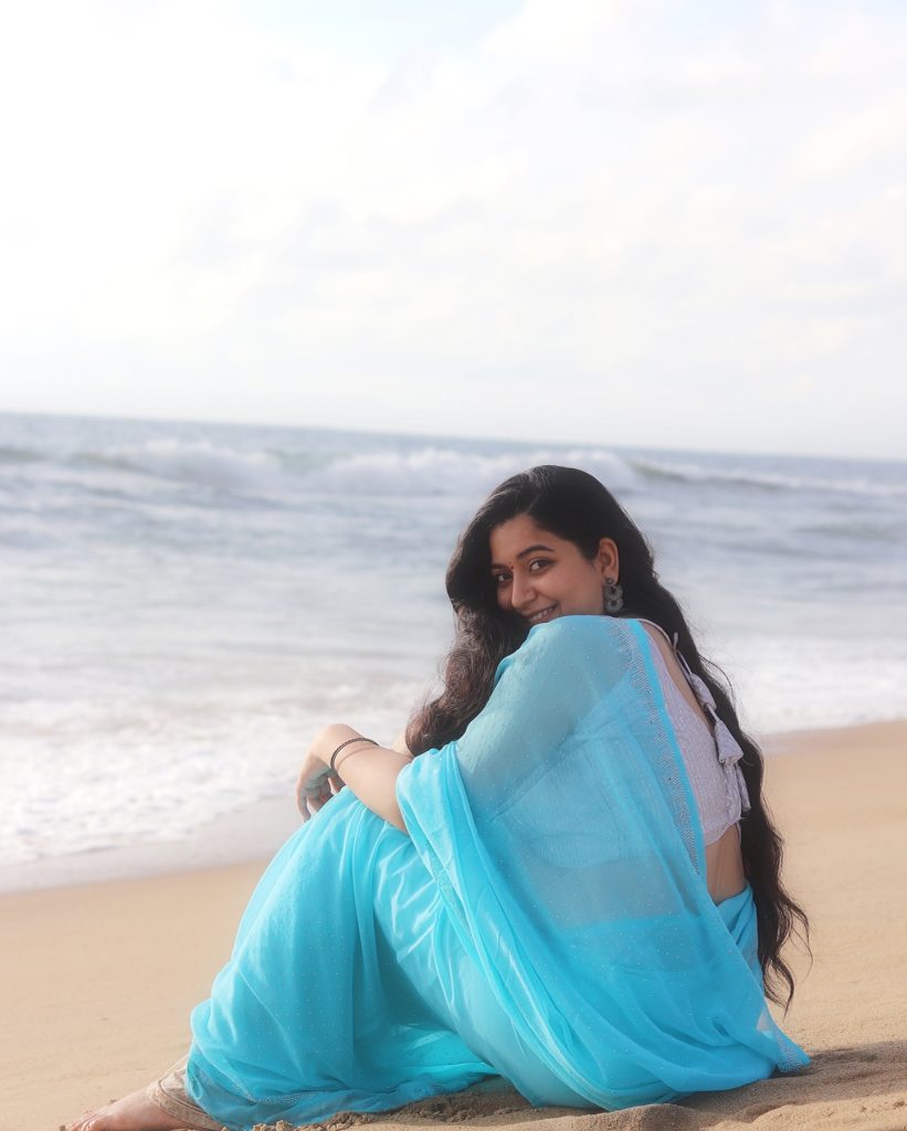 photoshoot captures Kanduri Sudha in traditional blue drape against ocean